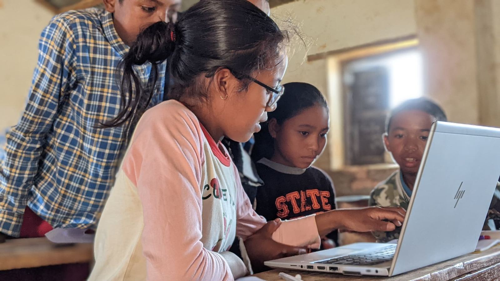 Students gathered around a laptop during a 2024 FromScratch session