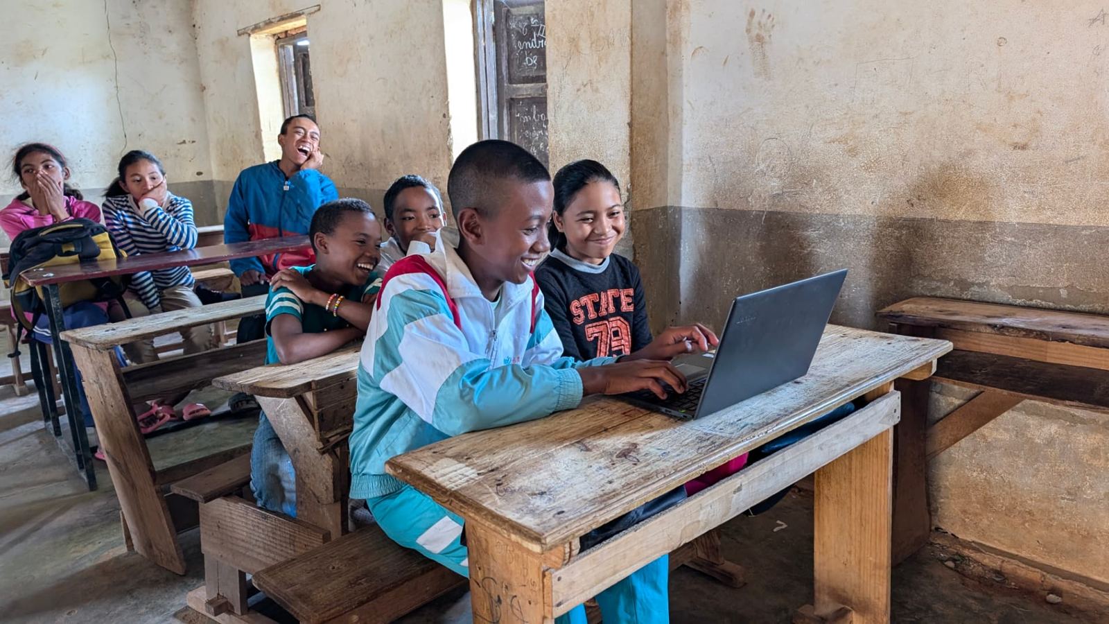 A classroom of teenagers laughing during a 2024 session at CEG Iarinarivo
