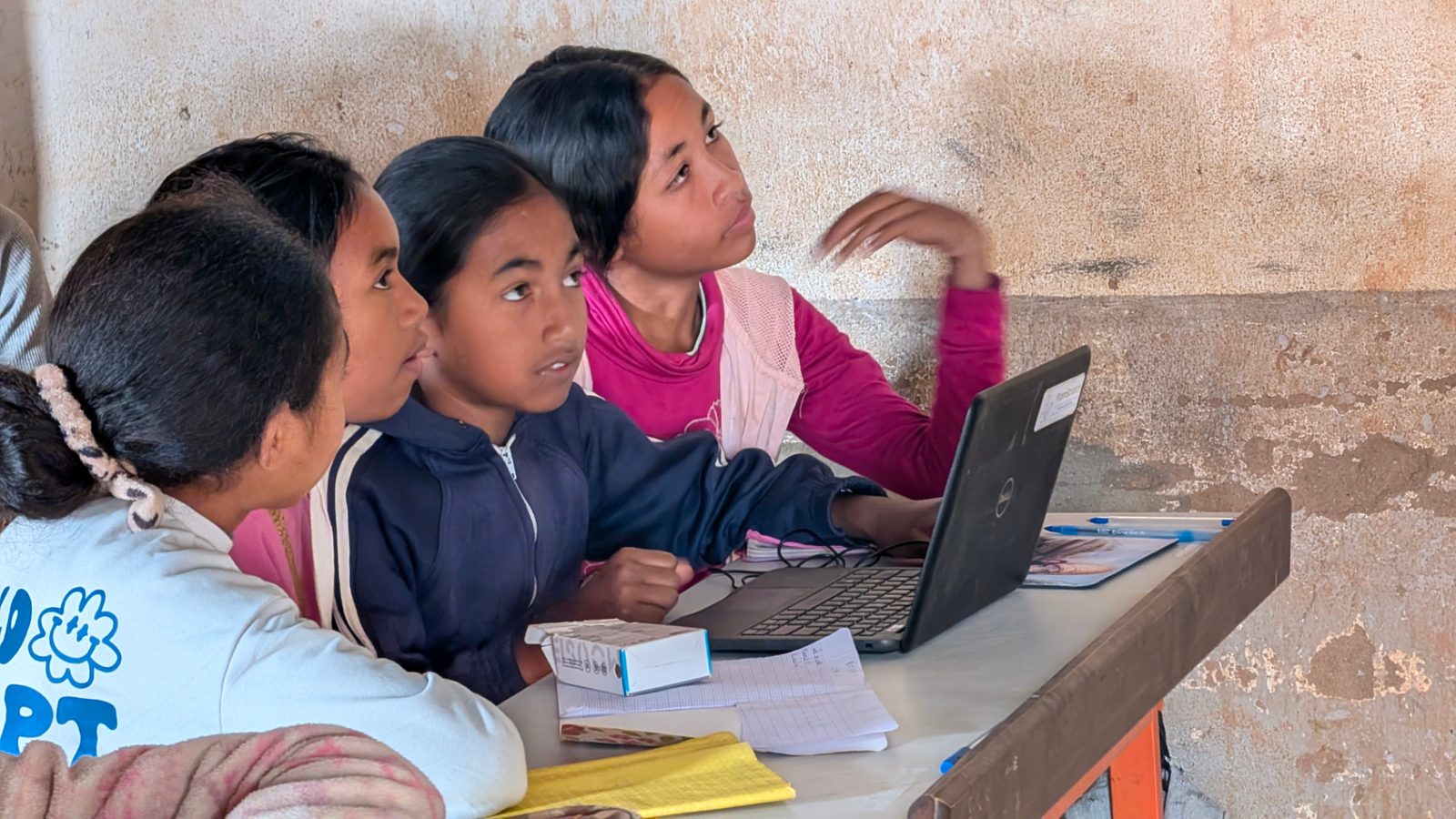 Three girls following a lesson on a laptop during a 2026 session
