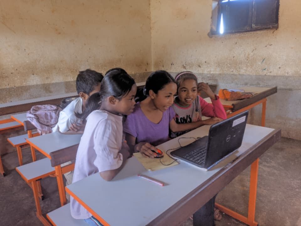 Students discovering a laptop together in a classroom, 2026